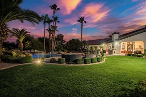 A well-maintained outdoor area with a swimming pool, seating, and a modern building with large windows. - $5Mil Luxury Estate - Pickleball Pool Hot Tub (Scottsdale)
