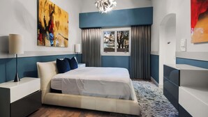 A modern hotel room with a bed, bedside tables, a large abstract painting, a window with curtains, and a chandelier. - $5Mil Luxury Estate - Pickleball Pool Hot Tub (Scottsdale)
