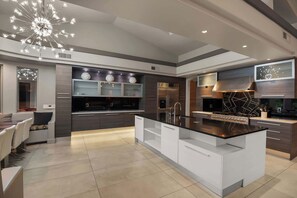 A modern kitchen with a central island, built-in appliances, and a contemporary light fixture. - $5Mil Luxury Estate - Pickleball Pool Hot Tub (Scottsdale)