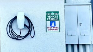 Señalización de 'Super 8' by Wyndham, un espacio de estacionamiento para vehículos eléctricos y una estación de carga.