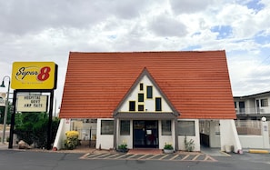 A building with a red roof, a sign for Super 8 by Wyndham, and a hospital government ARP rate sign. - Super 8 Downtown_2 Queen beds (Albuquerque)