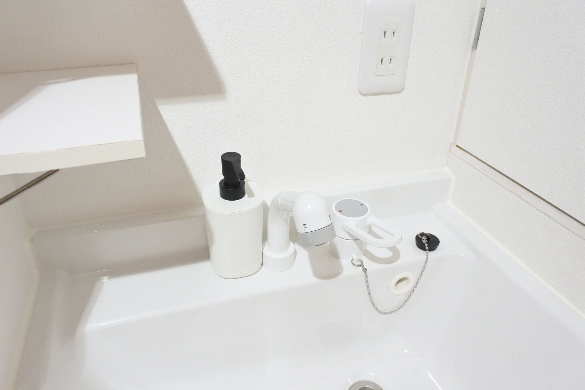 A white bathtub with a black faucet, a white towel, and a white bottle.