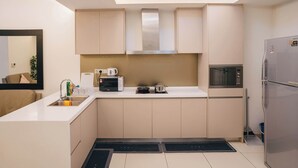 Een kleine keuken met een magnetron, waterkoker en een fornuis.