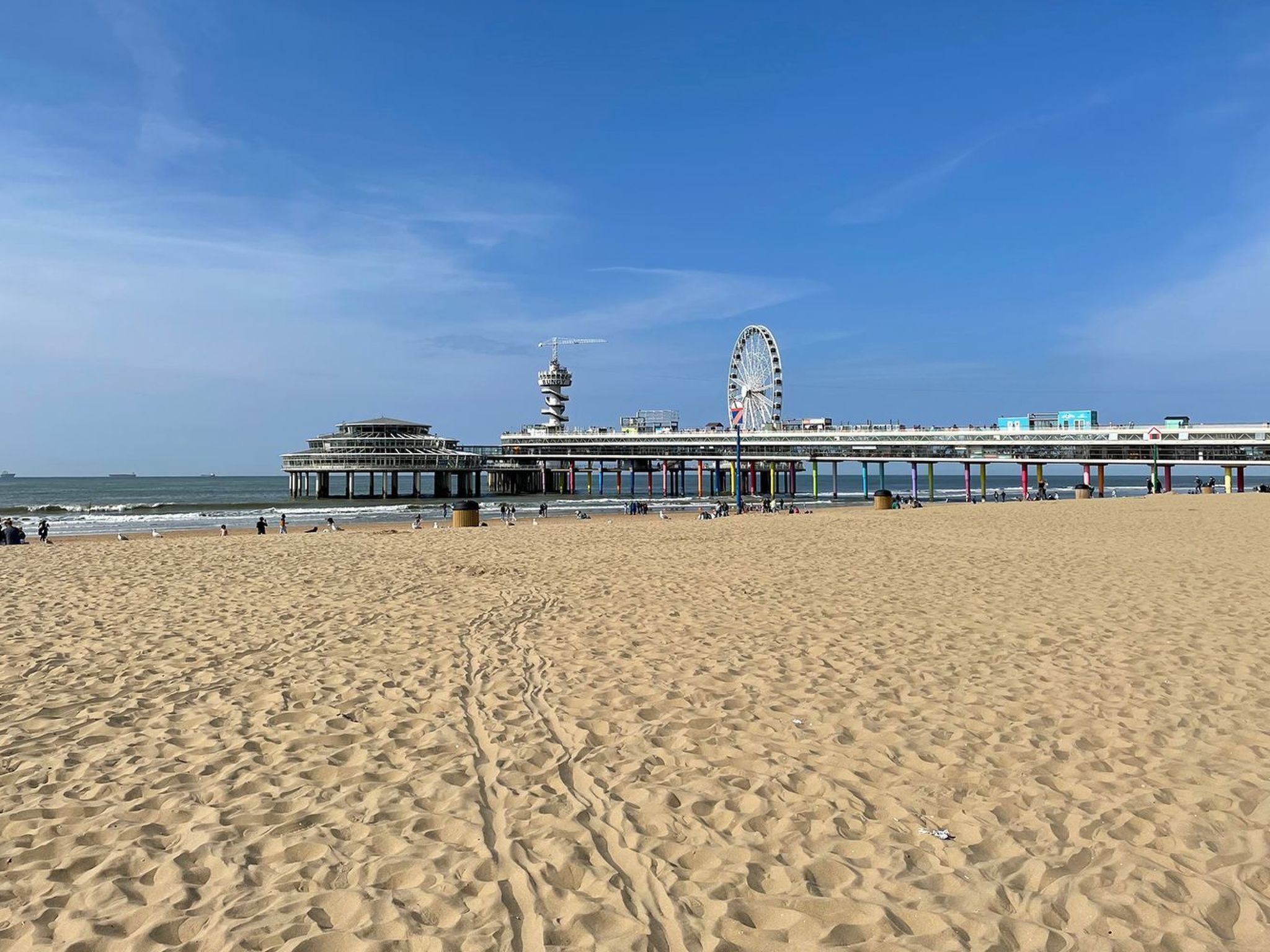 Une plage avec une jetée sur laquelle se trouvent une grande roue et une tour.
