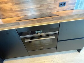 A kitchen with a built-in oven and a digital clock displaying 08:56. - Nordseeblick by Interhome (Katwijk)