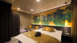 Ein Hotelzimmer mit einem großen Bett, einem kleinen Tisch und einem an der Wand befestigten Kunstwerk.