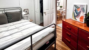 Una camera da letto con un letto, un armadio, una scrivania e una sedia.