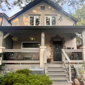 A two-story house with a front porch, a black front door, and a number '11' above the door. - A quiet stay in Toronto Waterfront Neighbourhood. Walk to the beach. (Toronto)