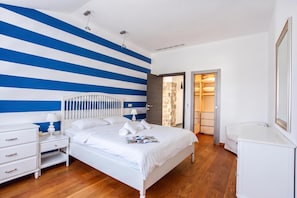 Ein Hotelzimmer mit Bett, Nachttischen, einem Kleiderschrank und einem Badezimmer.