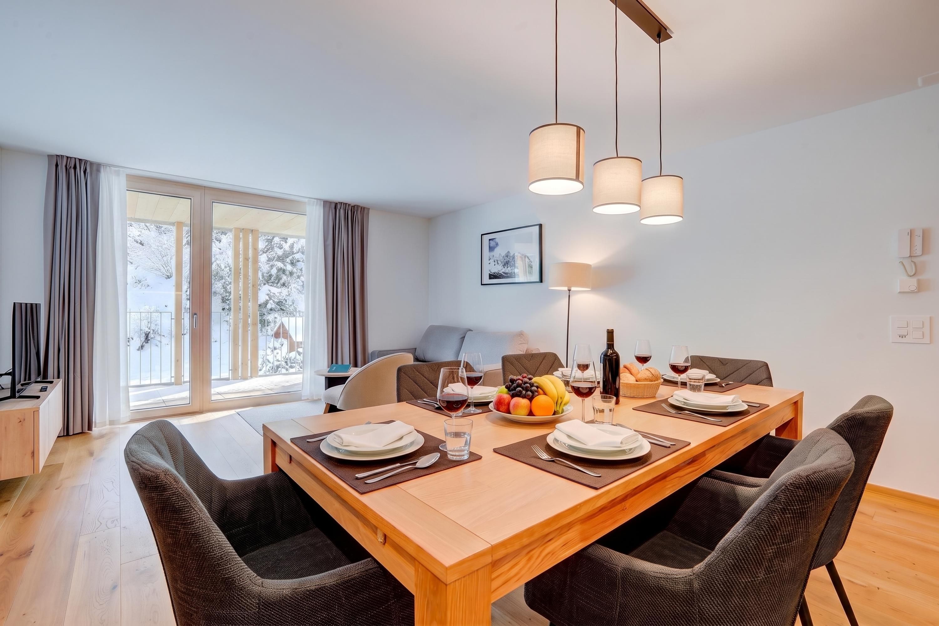 A dining area with a wooden table set for four, surrounded by dark woven chairs.