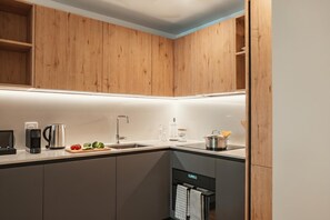 Een moderne keuken met houten kastjes, een roestvrijstalen spoelbak en een inbouwoven.