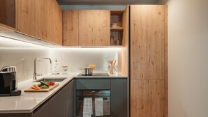A modern kitchen with wooden cabinets, a stainless steel sink, and a built-in oven. - Residenza Castanea 208 Modern Alpine Stay in San Bernardino | Ski, Hiking & Nature, San Bernardino, Switzerland (San Bernardino)