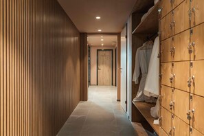 Ein Flur mit Holzwandverkleidung, gefliestem Boden und einem Schrank mit Kleiderstange.