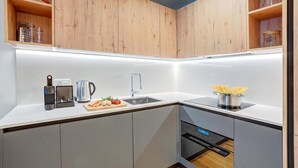 Et moderne køkken med træskabe, en stålvask og en indbygget ovn.