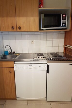 Una cocina compacta equipada con microondas, estufa y lavavajillas.