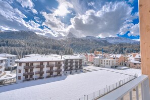 Un pueblo cubierto de nieve con edificios modernos y un imponente pico de montaña al fondo.