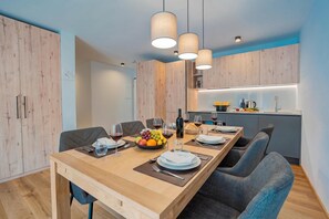 Un comedor moderno con una mesa de madera dispuesta para cuatro personas, rodeada de sillas.