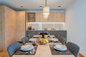 Un espace repas moderne avec une table en bois, dressée pour six personnes, entourée de chaises.
