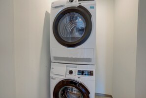 A stacked washer and dryer unit in a laundry room.