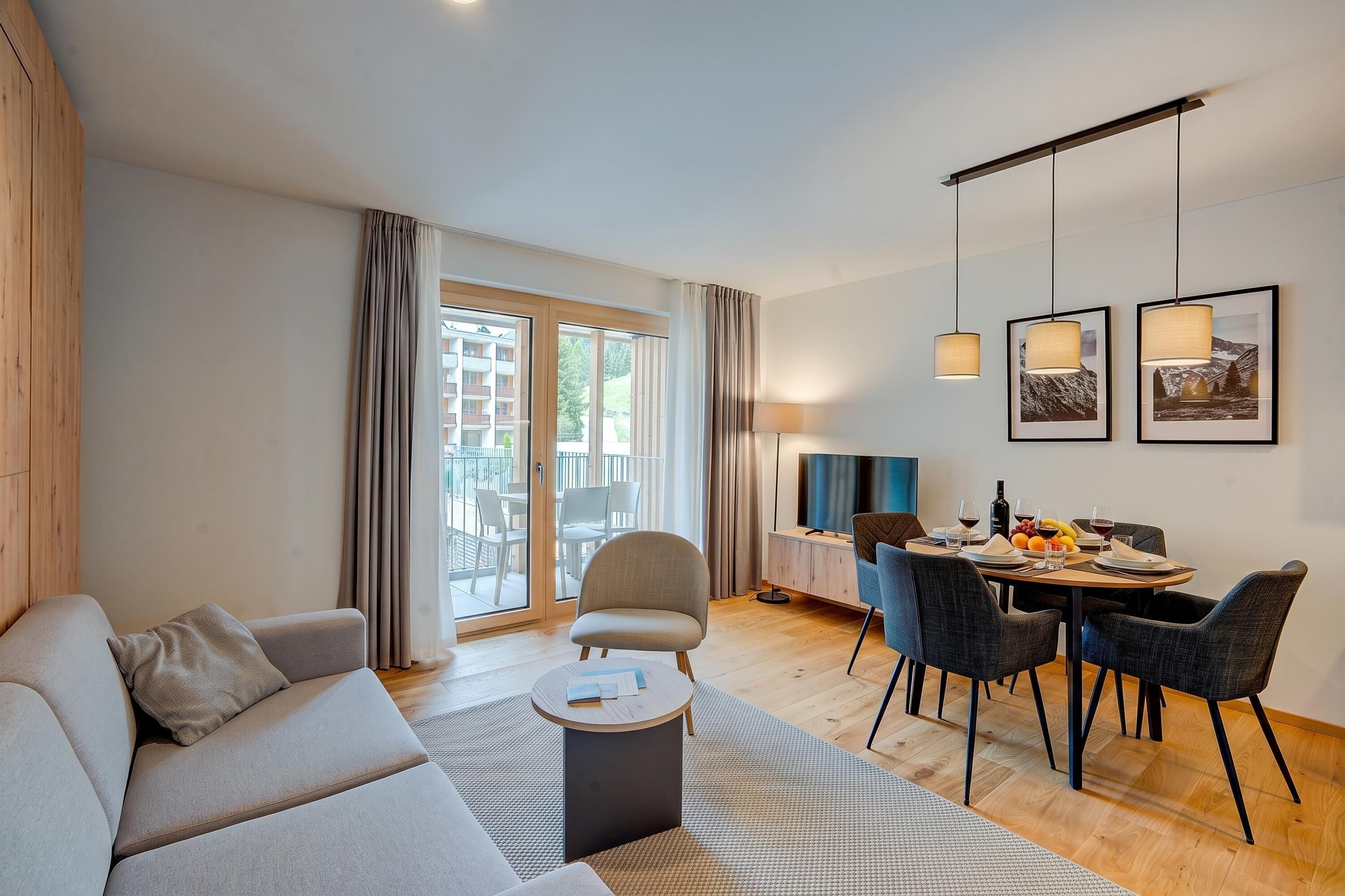 Un salon moderne comprenant un canapé, une table à manger, des chaises et un téléviseur.