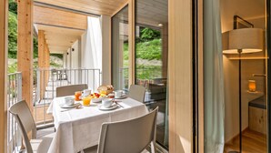 A dining area with a table set for breakfast, including bread, fruit, and beverages. - Residenza Castanea 107 Modern Alpine Stay in San Bernardino | Ski, Hiking & Nature, San Bernardino, Switzerland (San Bernardino)
