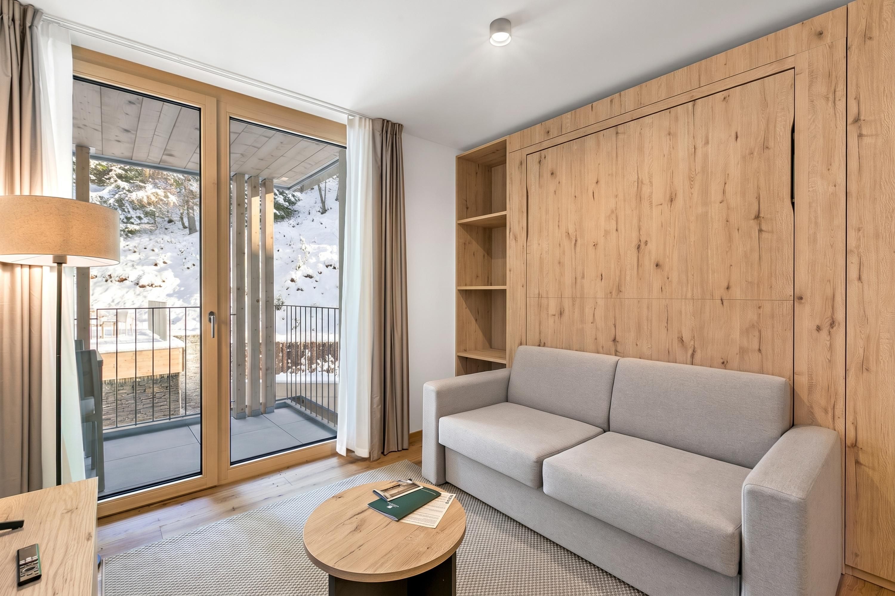 A modern living room with a sofa, a round coffee table, and a wooden cabinet.