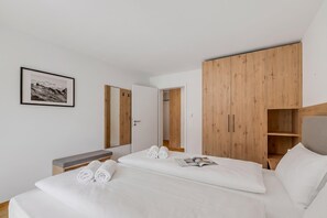 Ein Hotelzimmer mit einem Bett, einem Nachttisch, einem Schrank und einem gerahmten Bild an der Wand.