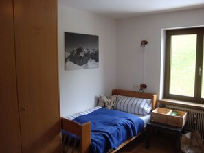 A small bedroom with a single bed, a radiator, a window, and a wall-mounted picture. - Oberlech in Lech by Interhome (Lech)