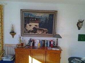 A room with a wooden cabinet, a framed painting, a lamp, and a mounted animal head. - Oberlech in Lech by Interhome (Lech)