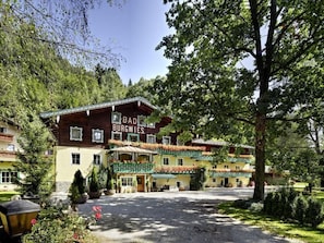 En traditionell byggnad i chaletstil med en skylt som visar texten ”BAD BURGWIES”.