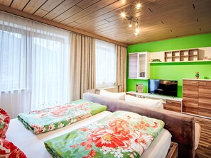 A hotel room with a bed, a sofa, a TV, and a green wall. - nahe den Skigebieten und Ausgangspunkt zu Sehenswürdigkeiten by Interhome (Mittersill)