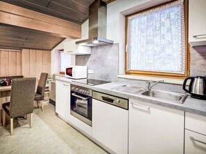 A modern kitchen with a built-in oven, microwave, and stainless steel sink. - nahe den Skigebieten und Ausgangspunkt zu Sehenswürdigkeiten by Interhome (Mittersill)