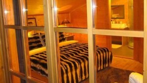Una habitación con una cama, una silla y un espejo.