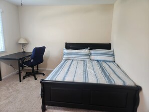 A bedroom with a bed, a desk, and a chair. - Relax 'N Recharge @ beautiful 4-bedroom house with pool in welcoming Wilmington (Wilmington)