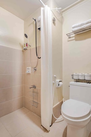 A bathroom with a shower, toilet, and a towel rack. - Studio Lune | Modern Makati Studio | Queen Bed | Fast Wi-Fi | Self Check-in ⭐ (Makati City)