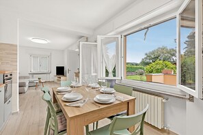 Eine moderne Küche mit Essbereich, Fernseher und Blick ins Freie.