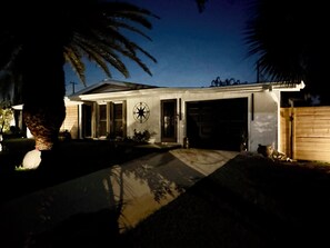 A modern house with a garage, a compass sign on the wall, and a well-maintained lawn. - Charming 3-bedroom house with pool in beautiful Palm Bay (Palm Bay)