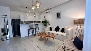 Um espaço de estar moderno com cozinha, área de jantar e assentos.