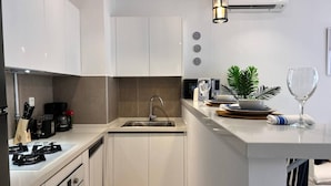 A modern kitchen with a sink, stove, and microwave. - F11 Appartement Douillet à La Marsa (La Marsa)