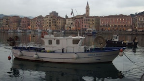 A boat named DANIELA IM 1023 docked at a harbor with buildings in the background. - Due Anime Felice by Interhome (Vasia)