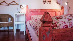 A room with a bed, a chair, a bedside table, and a wall-mounted lamp. - Due Anime Felice by Interhome (Vasia)
