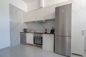 A modern kitchen with a dishwasher, microwave, oven, and refrigerator. - Portazgo Apartment | 2 Bedrooms + Sofa Bed (Madrid)