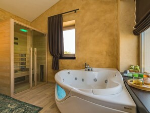 A modern bathroom with a large freestanding bathtub, a glass-enclosed shower, and a window with curtains. - Villa Maslina by Interhome (Dracevac)