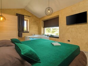 A bedroom with a bed, a window, a flat-screen TV, and a bathtub. - Villa Maslina by Interhome (Dracevac)