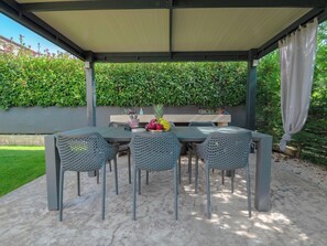An outdoor patio with a table and chairs, a grill, and a hedge in the background. - Villa Lavanda by Interhome (Poreč/Nova Vas)