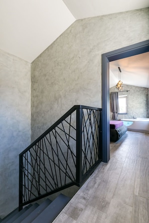 A staircase with a black metal railing leading to a room with a bathtub and a hanging light fixture. - Villa Lavanda by Interhome (Poreč/Nova Vas)