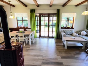 A spacious room with a dining area, a sofa, and a coffee table.