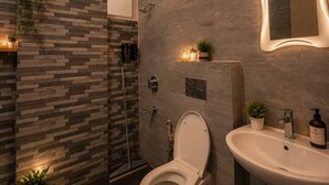 Un baño moderno con inodoro, lavamanos y ducha.