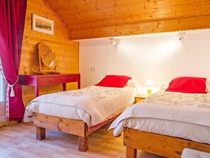 A cozy room with two wooden beds, a mirror, and a wardrobe. - Chalet la Chapelle by Interhome (La Chapelle d'Abondance)