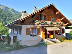 A wooden chalet with a balcony, a small porch, and a mountain backdrop. - Chalet la Chapelle by Interhome (La Chapelle d'Abondance)